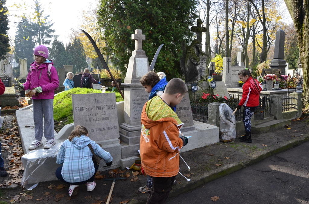 Łódź. Dzieci sprzątają nagrobki na Starym Cmentarzu