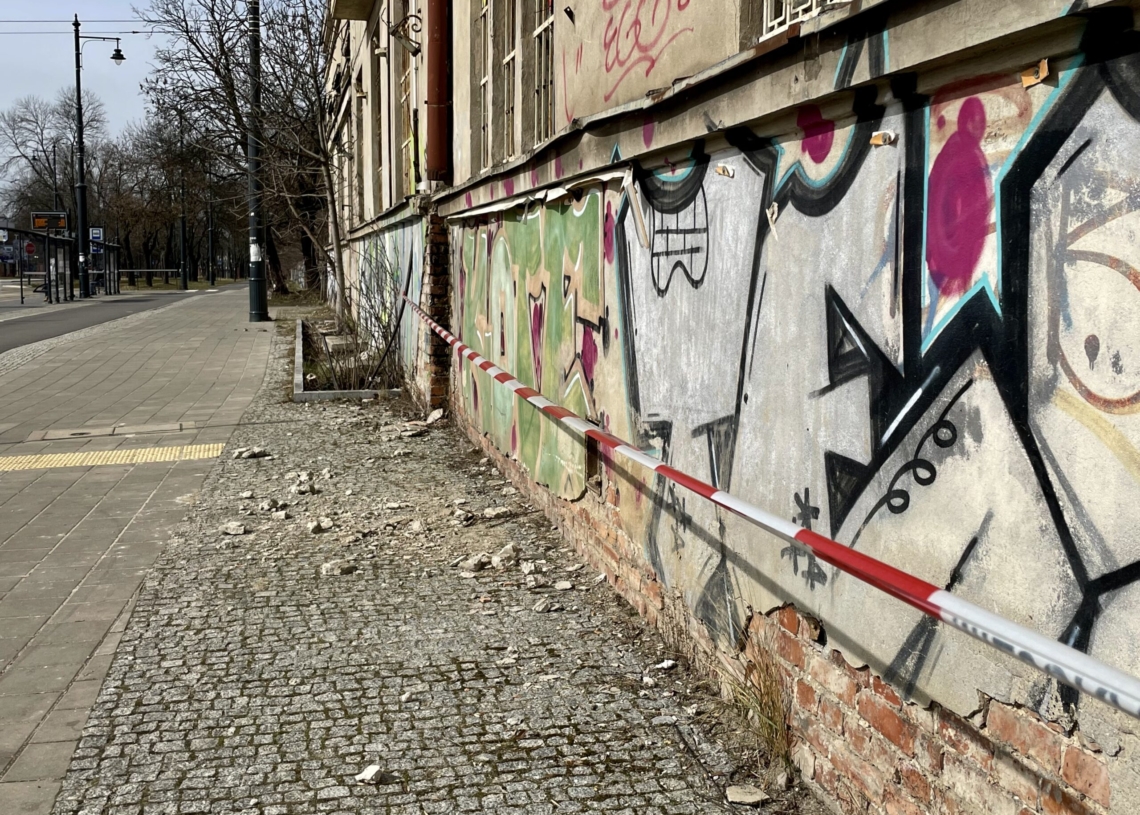 Spada tynk z budynku administracyjnego dawnej zajezdni Dąbrowskiego. Piesi powinni omijać go szerokim łukiem [ZDJĘCIA]