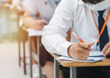 college students writing final examination papers classroom concentratively scaled
