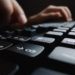 close up soft focus finger typing keyboard scaled