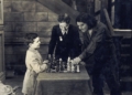 Partia Samuela Reshevsky'ego z aktorem Douglasem Fairbanksem na planie "Trzech Muszkieterów", niemego filmu z 1921 roku. Pojedynkowi odtwórcy roli d'Artagnana z genialnym szachowym dzieckiem z Polski przygląda się Charlie Chaplin.