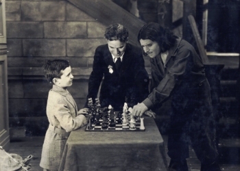 Partia Samuela Reshevsky'ego z aktorem Douglasem Fairbanksem na planie "Trzech Muszkieterów", niemego filmu z 1921 roku. Pojedynkowi odtwórcy roli d'Artagnana z genialnym szachowym dzieckiem z Polski przygląda się Charlie Chaplin.