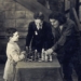 Partia Samuela Reshevsky'ego z aktorem Douglasem Fairbanksem na planie "Trzech Muszkieterów", niemego filmu z 1921 roku. Pojedynkowi odtwórcy roli d'Artagnana z genialnym szachowym dzieckiem z Polski przygląda się Charlie Chaplin.